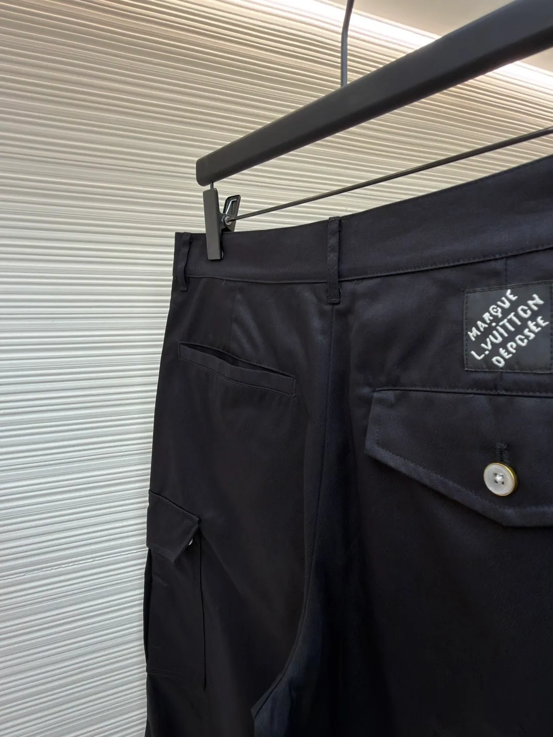 LOUIS VUITTON pocket embroidered work trousers ●Original version: Purchased and developed by 12324 ●Item number: 1682341-B50 ●Fabric: cotton twill fabric ●Technology: embroidery production ●Color: black ●Version: fitted version ●Weight: about 535 grams ●Size: 44-46-48-50 ●Description: The high cotton content ensures the fabric's excellent breathability, durability and classic workwear texture, while the twill weave gives it unique wear resistance and stiffness. The special fabric technology solves the pain points of tight and stiff traditional overalls; it provides greater freedom when moving, significantly improves wearing comfort and flexibility, and achieves a balance between function and comfort. The application of three-dimensional core-spinning embroidery technology in the pocket position is achieved by adding additional cotton thread or foam as the core material to the pattern filling layer, and then using embroidery thread to fully cover the embroidery. The logo pattern is significantly protruded from the surface of the fabric, forming a full three-dimensional effect. This process not only enhances the visual impact and tactile level, but also improves the wear resistance of the pocket area through the buffering effect of the core material, ensuring that the pattern can still remain crisp and not deformed in complex daily use, ensuring that the pattern is clear and durable, and injecting a sense of sophistication into the rugged workwear style. Diversified pocket system combines workwear functionality with sophistication. The flap cargo pockets on both sides are a signature element, and their flap design prevents items from falling and enhances the visual three-dimensionality. Italian style pockets provide simple side storage. The overall wiring is straight and delicate, the fabric is comfortable and soft, and the color is consistent without color difference. It can be matched with the same style to create a fashionable look and control various occasions. Customized accessories, complete with three standards, same style for men and women!
